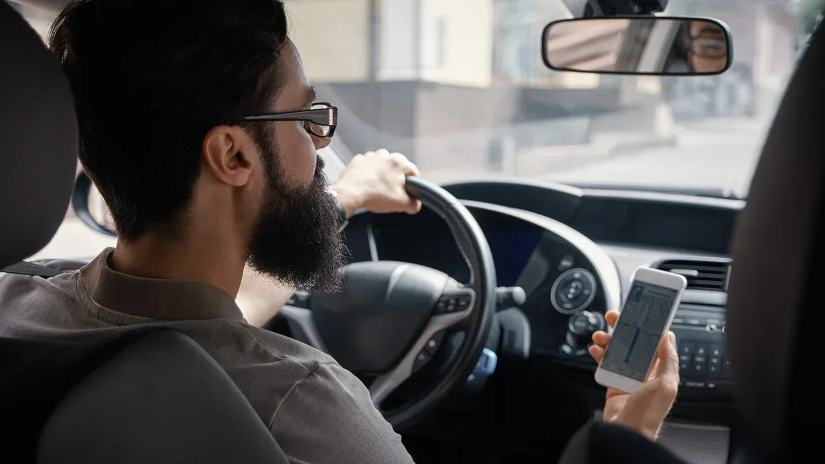 Homme utilisant un téléphone portable en conduisant.