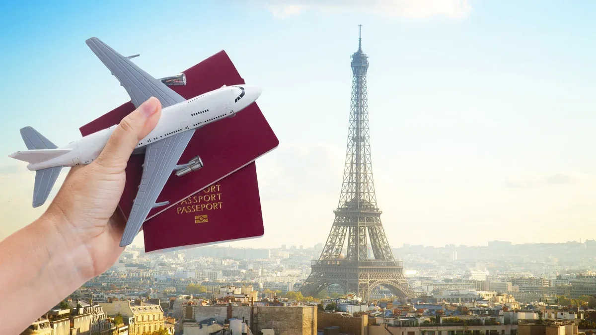 Concept de voyage en avion, main tenant des passeports avec avion, paysage urbain de Paris France en arrière-plan