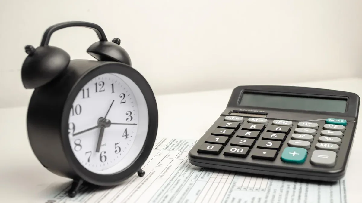 Voir en haut le formulaire d'impôt 1040 avec calculatrice à stylo et réveil noir document financier de l'heure d'imposition