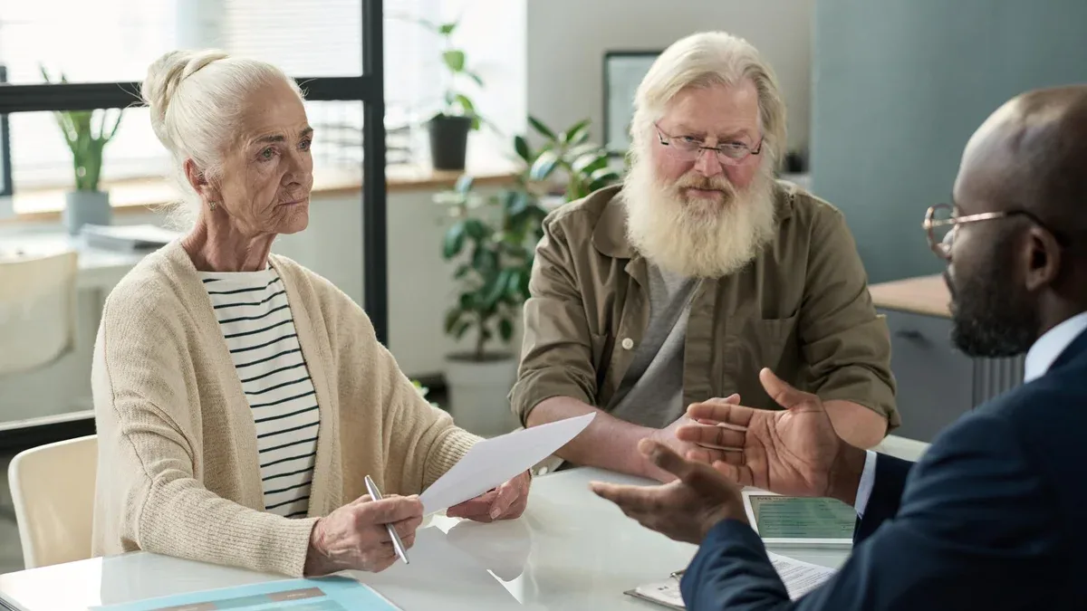 Un couple âgé discute d'un contrat d'hypothèque avec un agent.