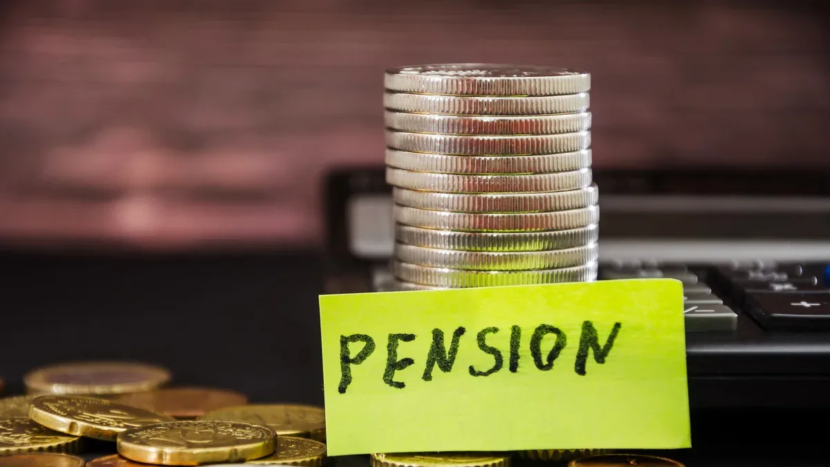 pile de pièces et le mot pension sur un autocollant concept d'épargne