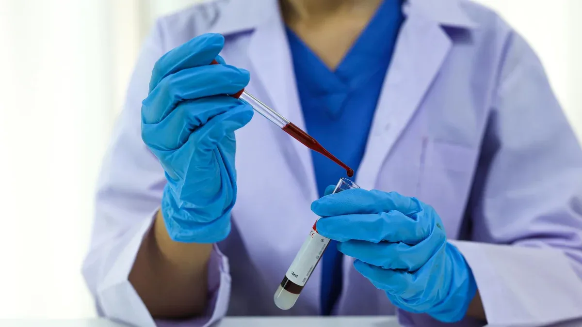 Un scientifique détenant un tube d'échantillon de sang infecté par le coronavirus covid-19 testant l'ADN du sang en laboratoire avec des tubes de collecte d'épreuves de sang et une seringue Recherche sur le vaccin contre le coronavirus Covid-19