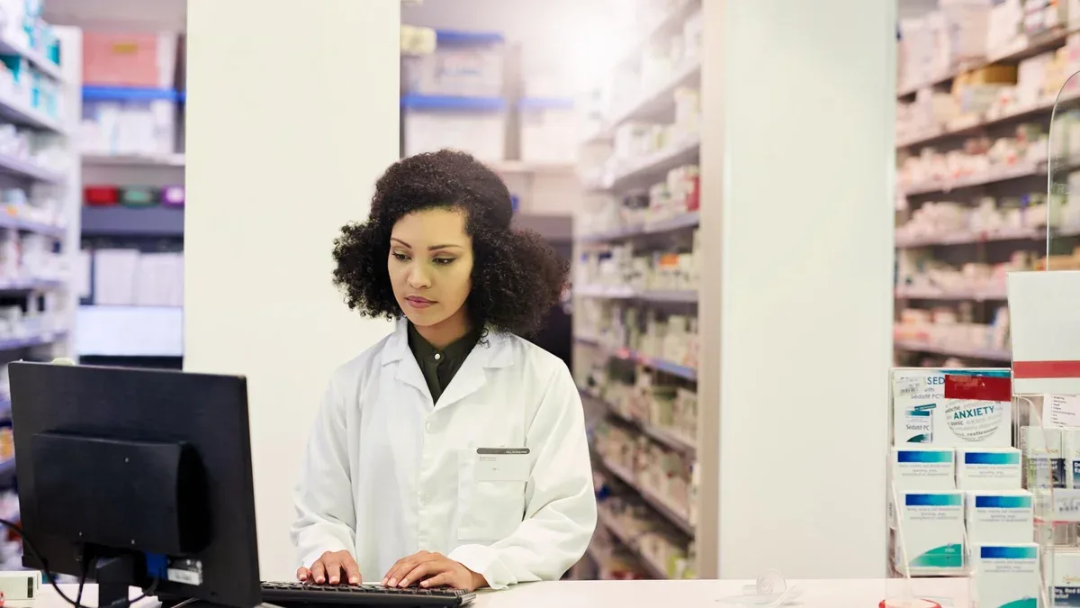 Je vais vous donner les médicaments dont vous avez besoin quand vous en avez besoin Photo recadrée d'un pharmacien travaillant sur un ordinateur dans une pharmacie