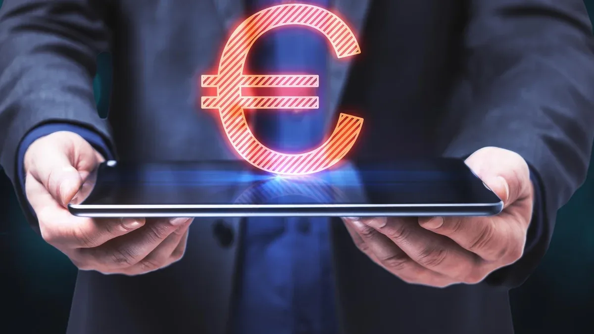 Gros plan sur des mains d'homme d'affaires tenant une tablette avec un signe euro rougeoyant abstrait sur fond bleu Monnaie en ligne bancaire et concept de marché