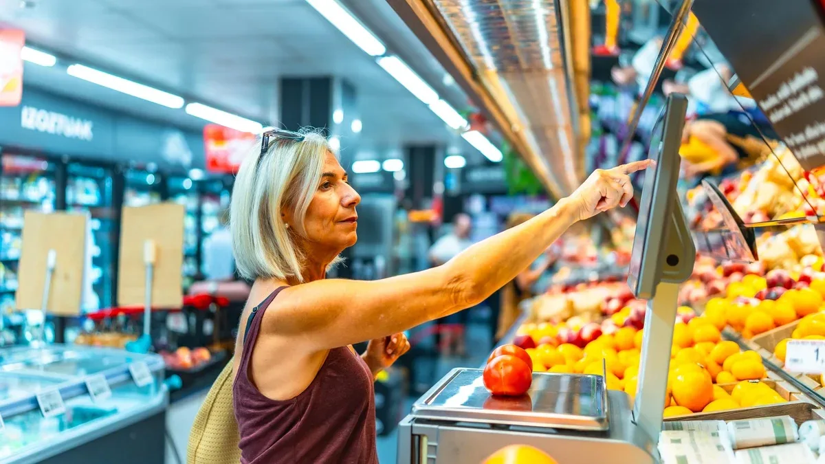 Femme utilisant une balance numérique dans une épicerie