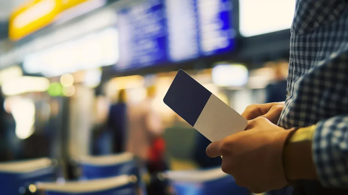 Personne non reconnaissable tenant une carte d'embarquement à l'aéroport