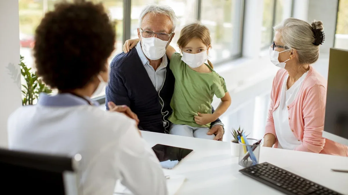 Un couple de seniors avec une petite-fille chez un médecin noir.